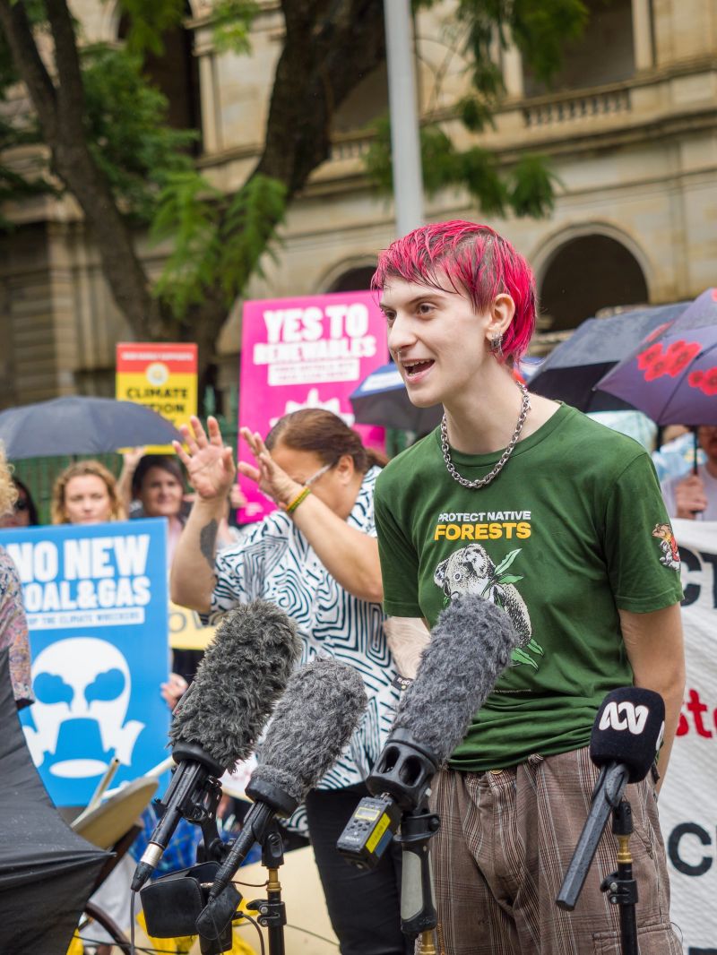 A person standing in front of various microphones at a press conference